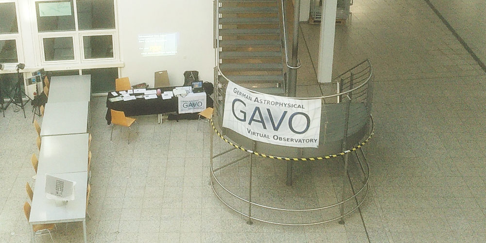 A shot from above to a large banner with the GAVO logo, and a booth with lots of papers behind it.  No person is visible (yet).